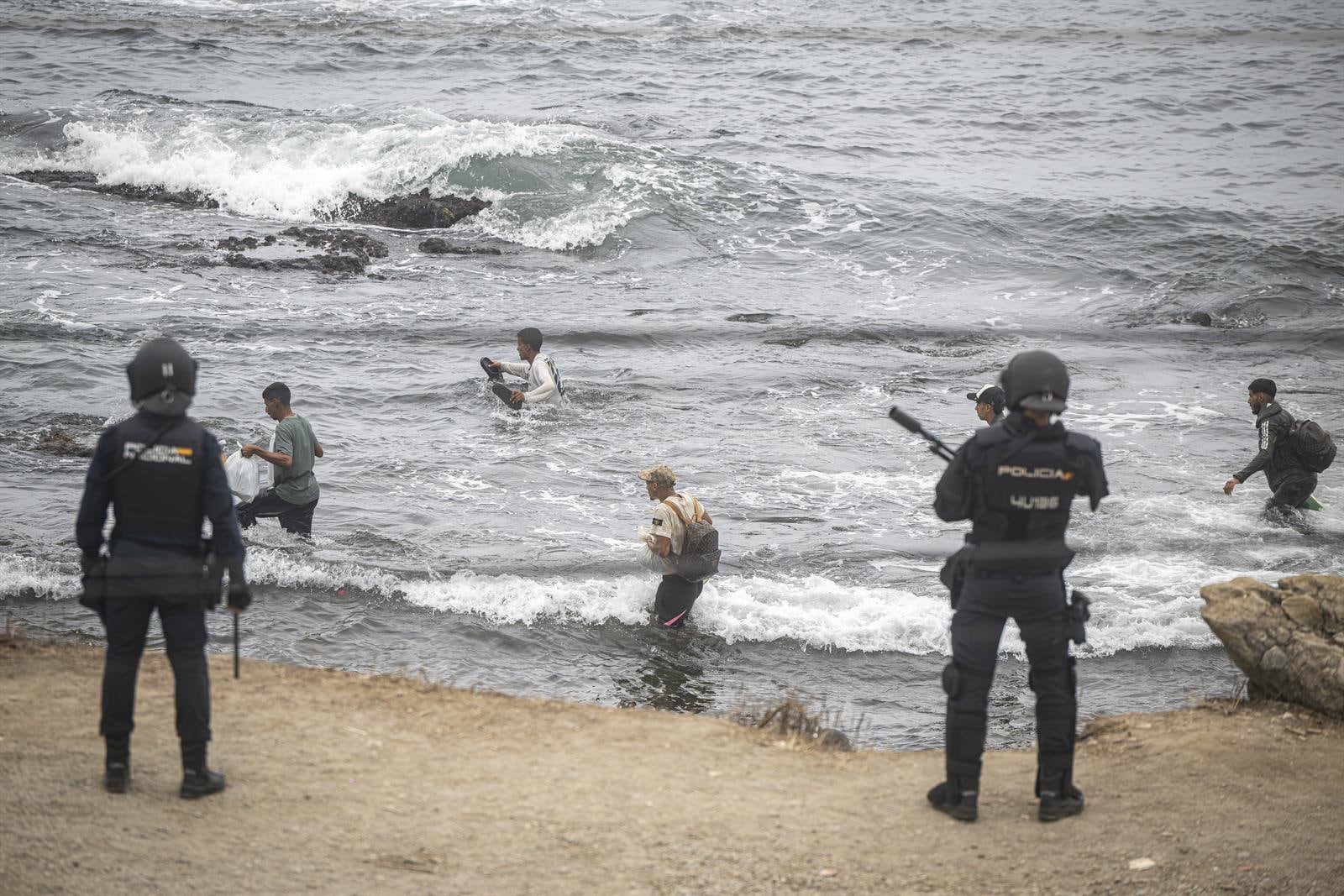 Agentes de la Policía Nacional intervienen durante el proceso de desalojo de la playa de El Trampolín, en Ceuta. (Marcos Moreno / Europa Press)