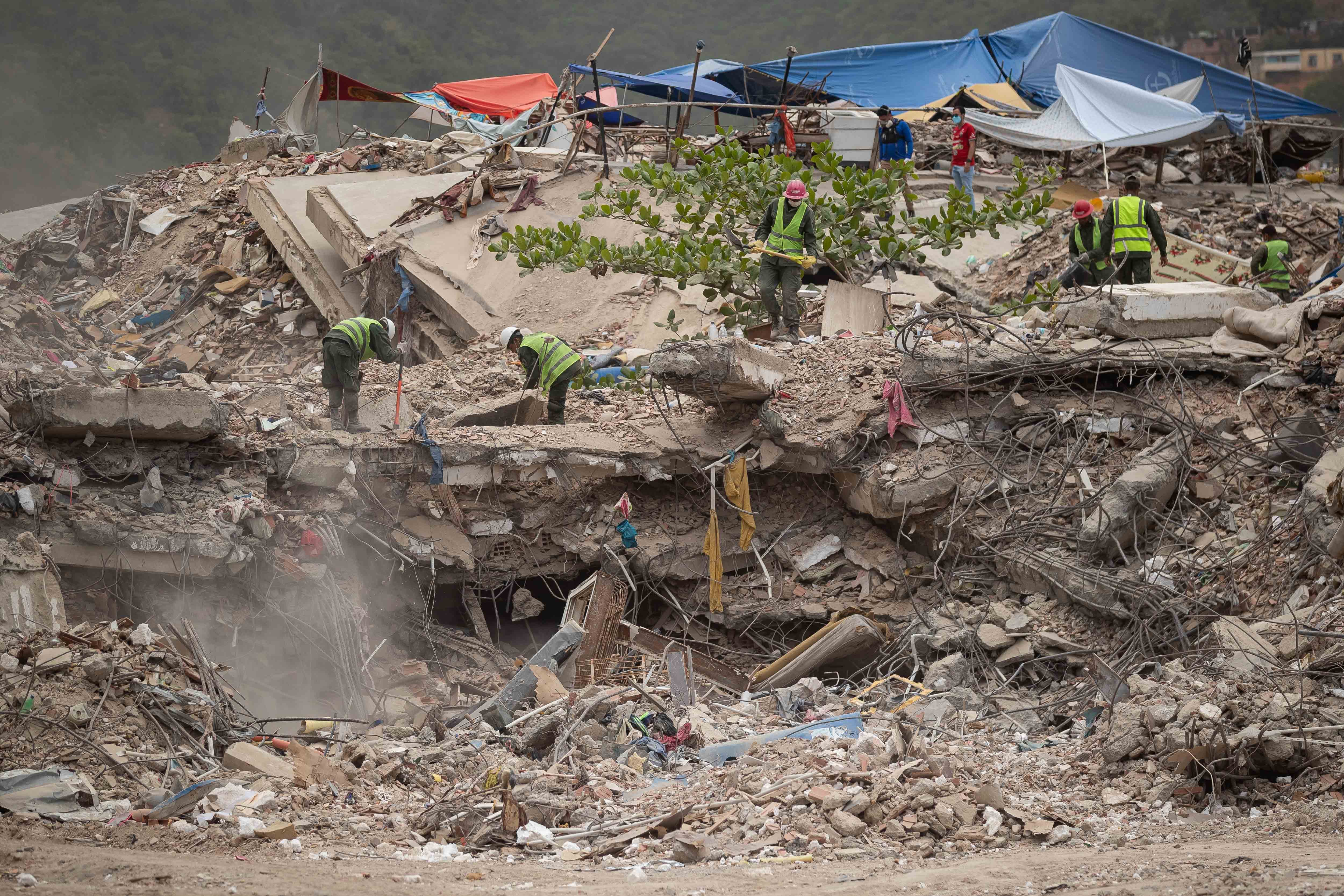 Personas remueven escombros de un edificio colapsado por los terremotos en La Guaira (EFE/Ronald Peña R)