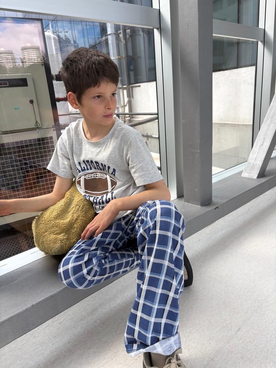 El niño Antonio Ventura permanece sentado junto a un ventanal durante su etapa de recuperación médica en un sanatorio