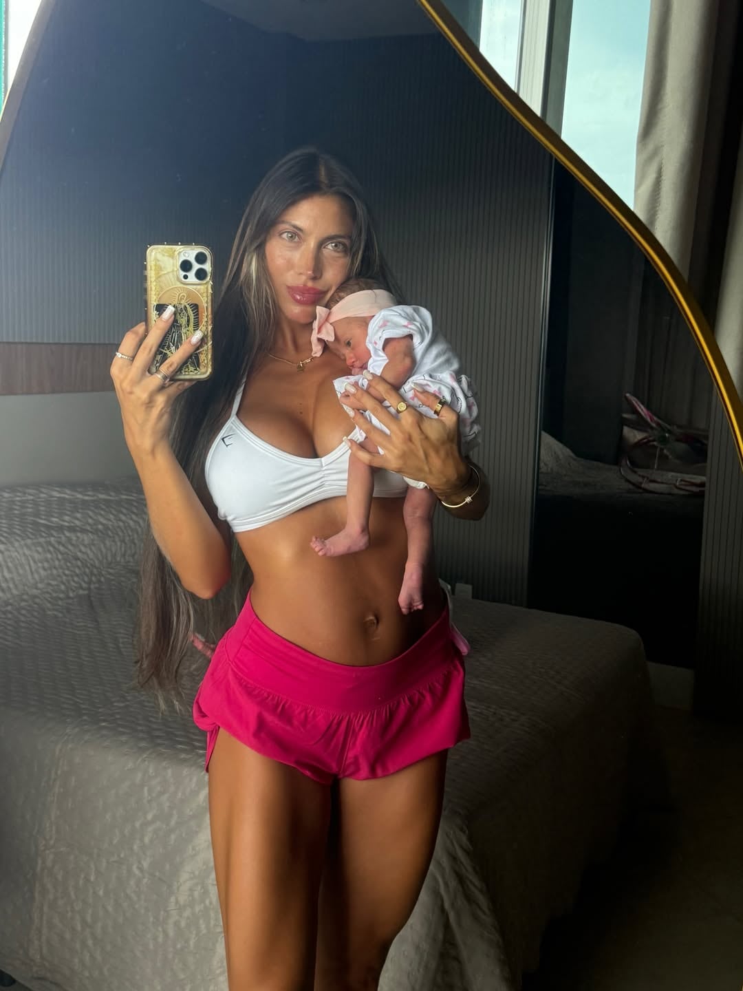 Cielo López, esposa del futbolista Claudio Spinelli, posa frente a un espejo junto a su bebé recién nacida en sus brazos.