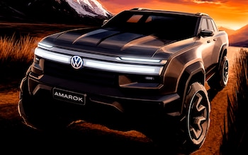 Pickup de color oscuro, marca Volkswagen, con logo frontal y la palabra 'AMAROK' en placa. Luces LED horizontales, neumáticos grandes, montañas nevadas y cielo anaranjado