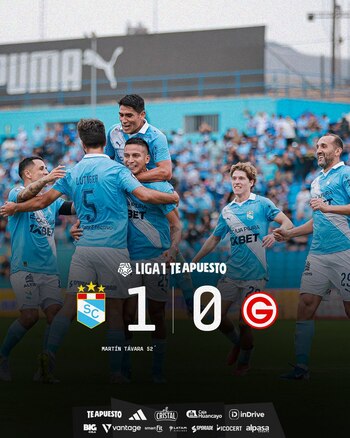 Seis futbolistas en uniforme celeste celebran en un campo de juego. Una infografía superpuesta muestra el marcador 1-0 para Sporting Cristal en la Liga 1