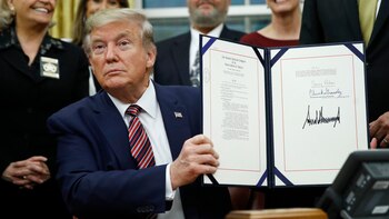 Donald Trump muestra la firma