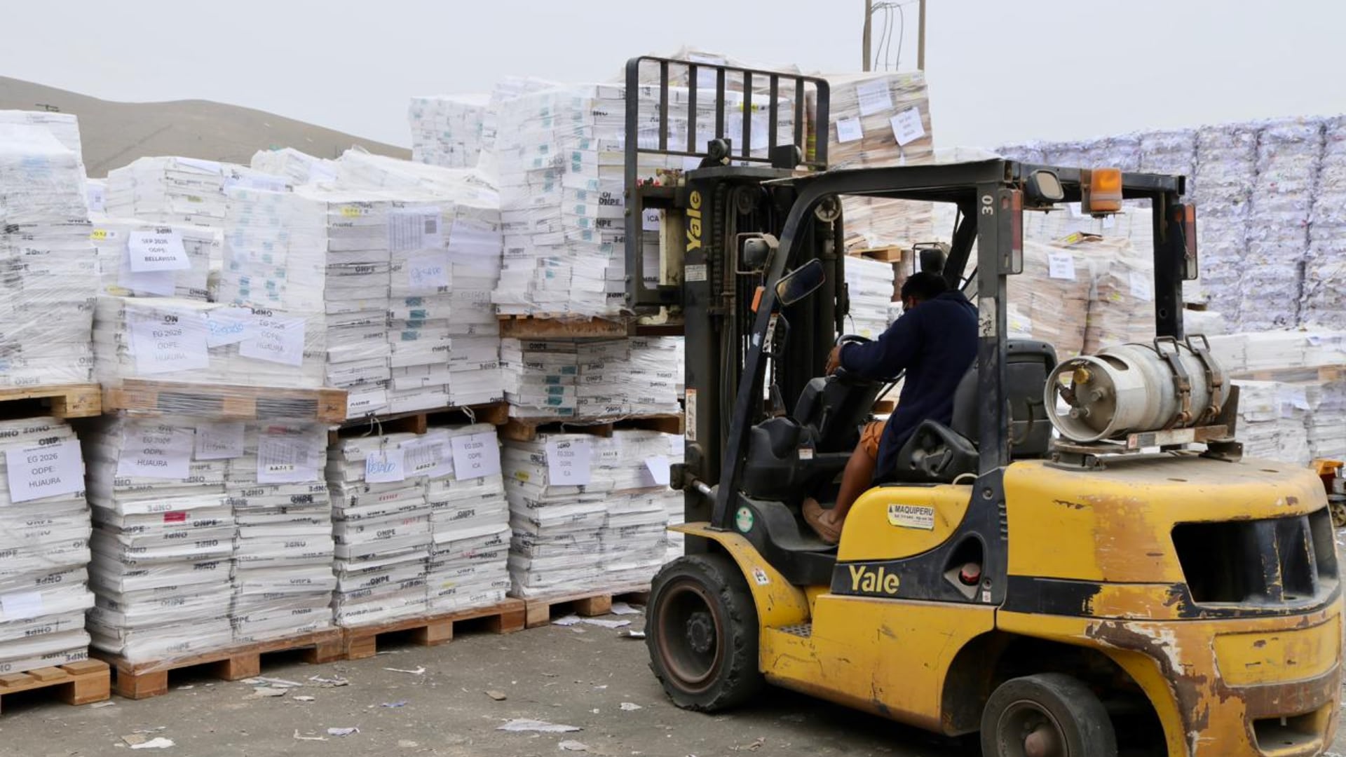 Un operario maneja un montacargas junto a palés de material electoral de la ONPE en Ventanilla durante el proceso de destrucción de cédulas de sufragio en Perú. (ONPE)