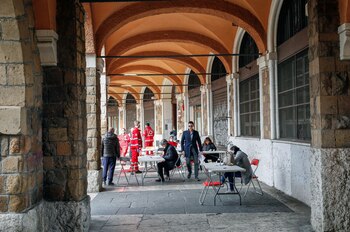 Personas con mascarillas hacen fila