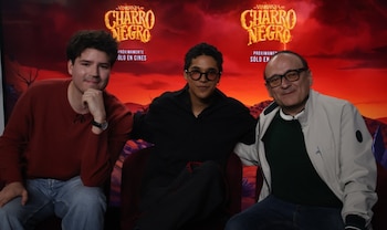 Tres hombres están sentados ante un fondo rojo promocional con el texto La venganza del Charro Negro