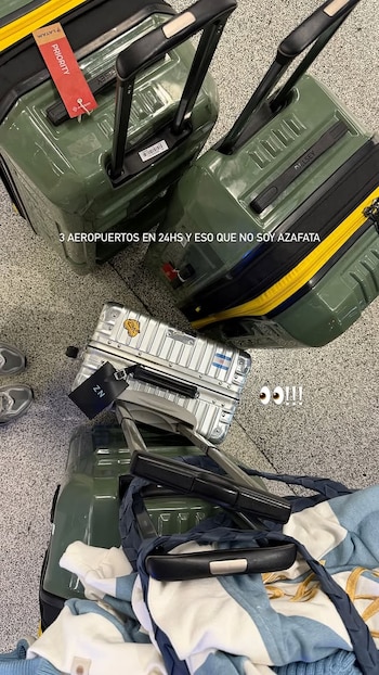 Tres maletas de viaje, dos verdes y una plateada, con asas y ruedas, sobre un suelo de baldosas grises. Se observa una etiqueta roja y otra negra con las iniciales ZN