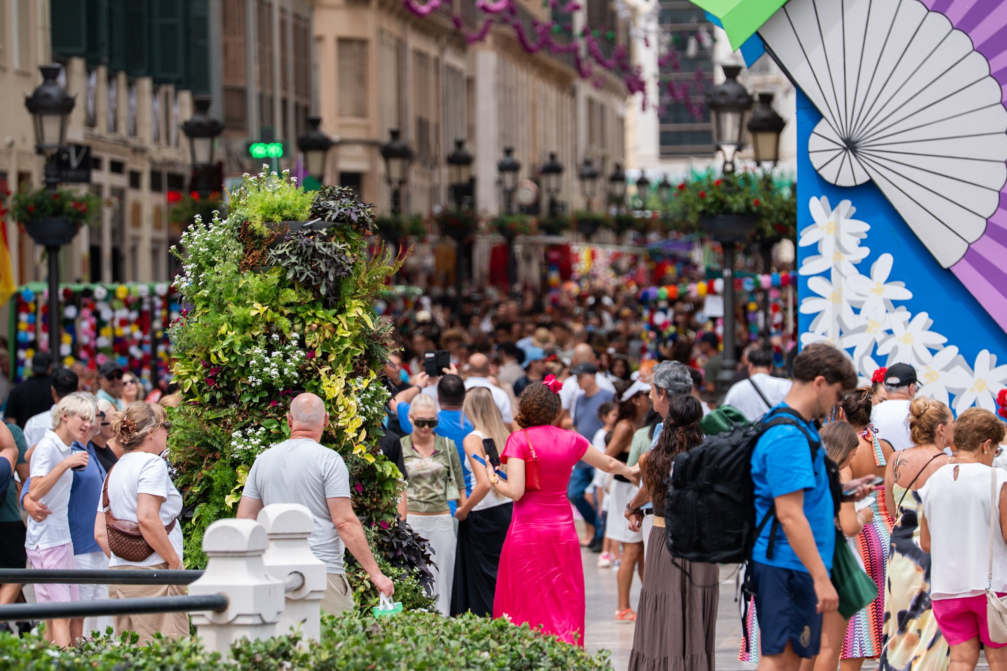Una calle céntrica de Málaga se llena de personas y adornos florales durante la celebración de la Feria. (Ayuntamiento de Málaga)