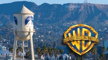 Una torre de agua con el logo de Paramount, el escudo dorado de Warner Bros. y el letrero de Hollywood en las colinas.