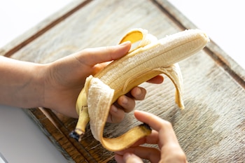 Una persona pelando un plátano