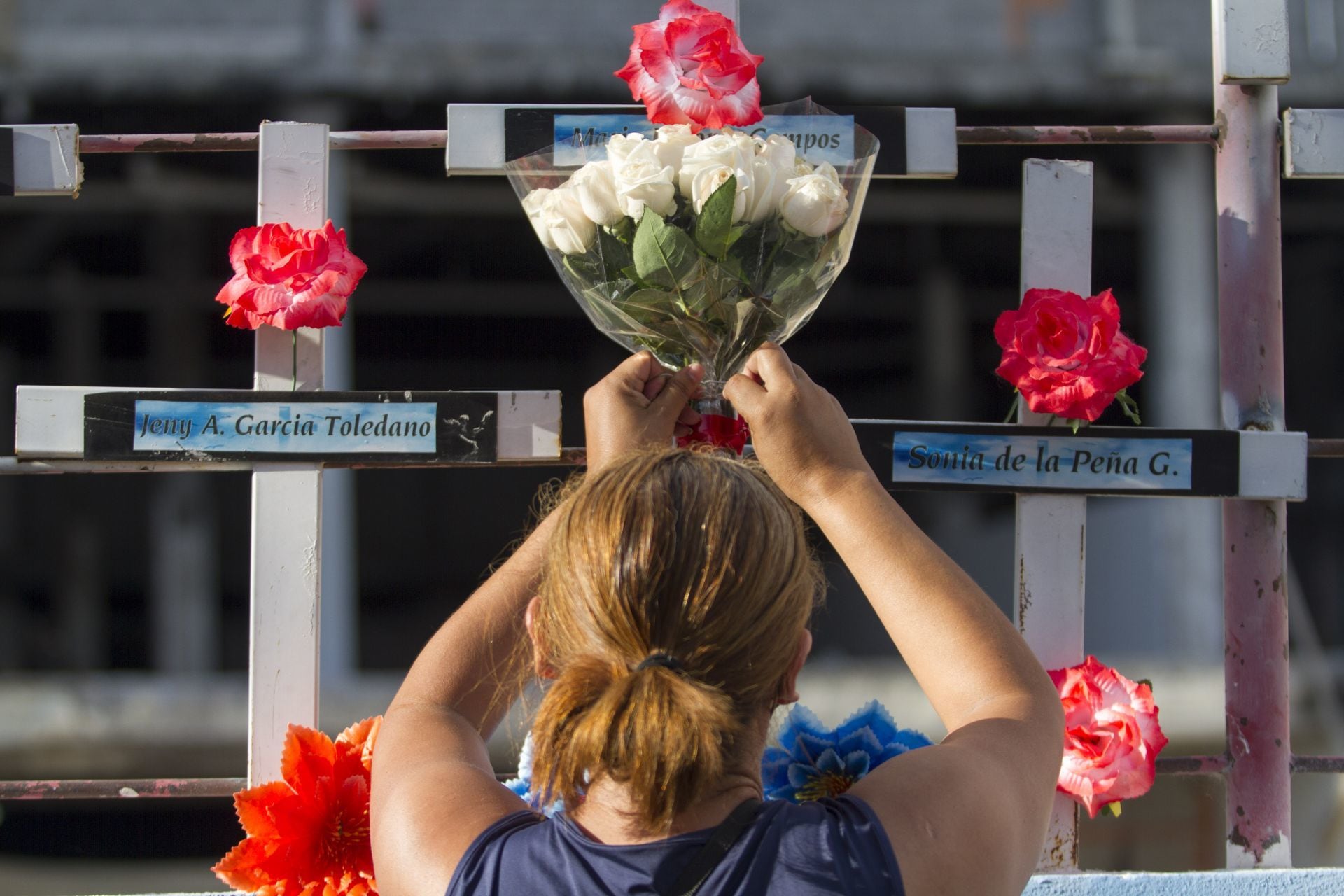 MONTERREY, NUEVO LEÓN, 25AGOSTO2021.- Familiares de víctimas del ataque al Casino Royale, donde murieron 52 personas, se reunieron en conmemoración del décimo aniversario donde colocaron flores y pintaron sus manos en el muro exterior exigiendo justicia para los deudos y sus familias.FOTO: GABRIELA PÉREZ MONTIEL / CUARTOSCURO.COM
