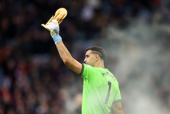 Dibu Martínez mostrando su trofeo