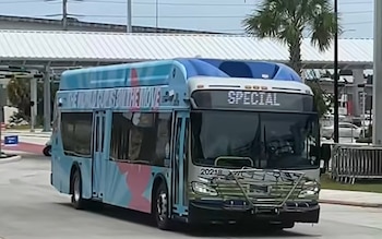 Autobús de tránsito azul, blanco y rosa con gráficos de la Copa Mundial 2026 en su costado, mostrando 'SPECIAL' en la pantalla frontal, en una calle