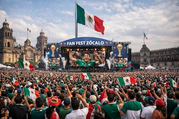 Multitud en el Fan Fest Zócalo, Ciudad de México. Banderas mexicanas, pantallas mostrando fútbol, gran bandera de México, confetti y edificios históricos.