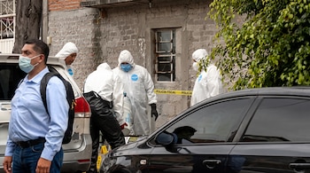 Personal con trajes de bioseguridad recaba pruebas junto a marcadores numéricos de evidencia en la vía pública.