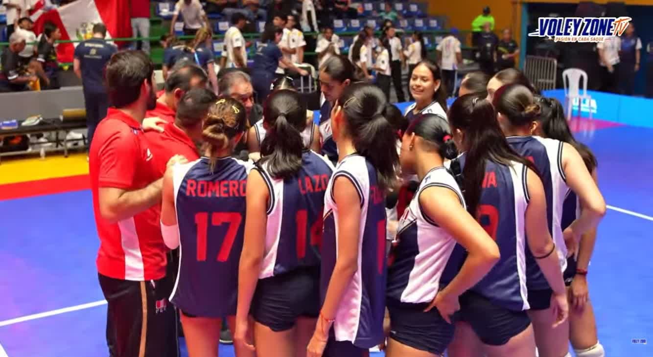 Jugadoras y cuerpo técnico de la selección peruana de vóley sub-19 conversan en la cancha durante un partido del Campeonato Sudamericano.