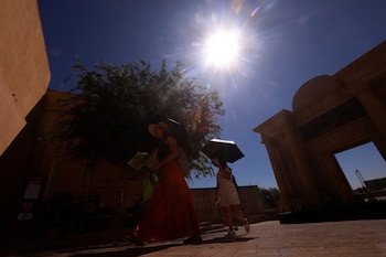 Turistas se protegen con paraguas para aliviar las altas temperaturas en Córdoba, a 8 de agosto de 2026. (EFE/ Salas)