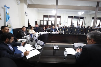 Cuatro mujeres sentadas en una mesa con micrófonos y placas con sus nombres en un salón del Congreso de la República