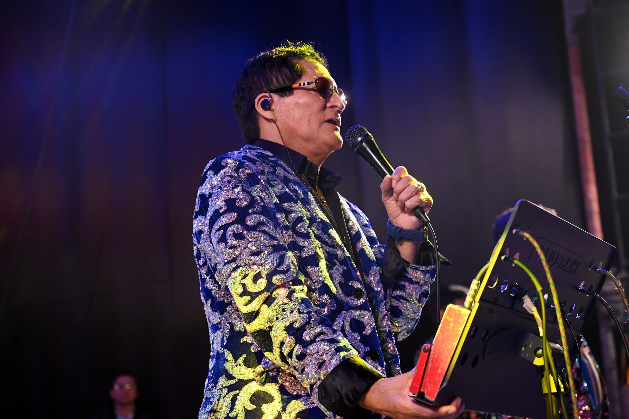 El cantante peruano Pascualillo Coronado interpreta un tema musical sobre el escenario durante un espectáculo en vivo.