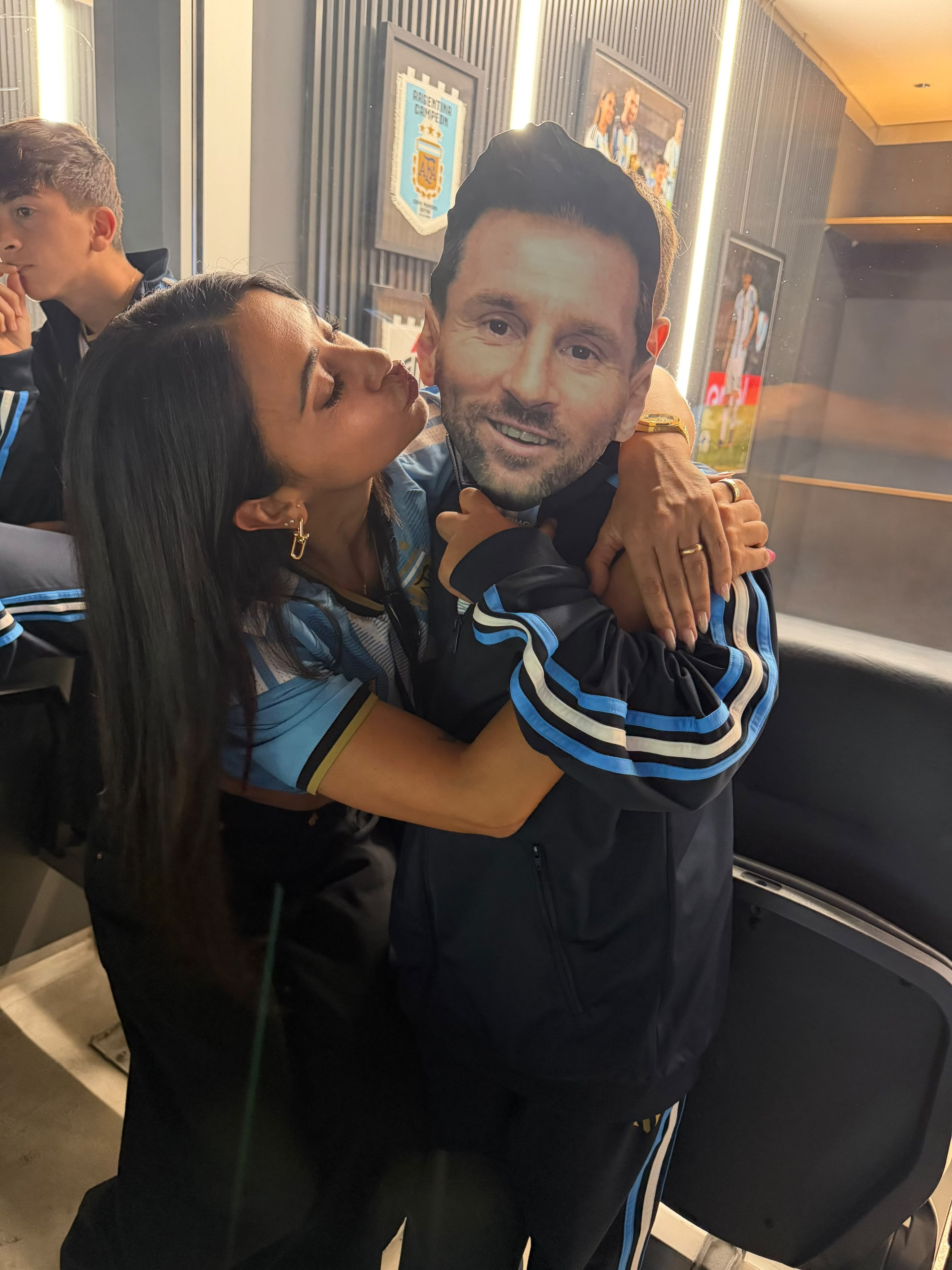 Antonela Roccuzzo besa una figura de cartón con el rostro de Lionel Messi, en un gesto afectuoso durante la despedida del capitán con la selección argentina
