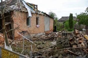 Una residente local mira la casa de su vecino, que fue dañada por un ataque aéreo ruso, en medio del ataque de Rusia contra Ucrania, en Kharkiv, Ucrania, el 18 de mayo de 2024. REUTERS/Valentyn Ogirenko