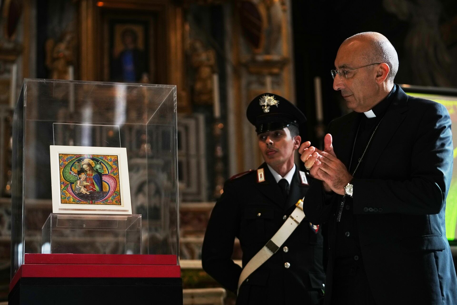 El cardenal Baldassare Reina aplaude frente a una página iluminada del siglo XV atribuida a Fra Antonio da Monza (Foto: AP / Alessandra Tarantino)