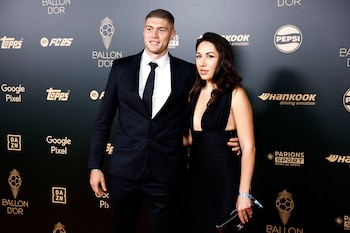 Artem Dovbyk, futbolista ucraniano nominado al Balón de Oro, posó junto a su esposa Yuliia. Él vistió un traje negro clásico, combinado con camisa blanca y corbata negra, logrando una apariencia formal y elegante. Ella mostró un vestido largo y negro de diseño sencillo, pero sofisticado, con un pronunciado escote que aporta un toque de elegancia moderna. (REUTERS/Sarah Meyssonnier)