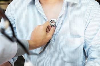 Un doctor ausculta a un paciente (Magnific)