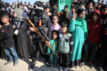 Un pistolero palestino hace guardia junto a unos niños en Gaza.