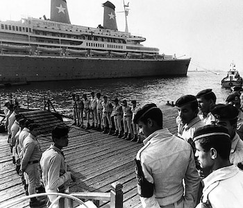 La policía central de seguridad egipcia vigila la pasarela por la que diplomáticos y otras personas van y vienen del crucero italiano, que llegó el jueves 10 de octubre de 1985 a Port Said, tras ser secuestrado por cuatro palestinos (AP)