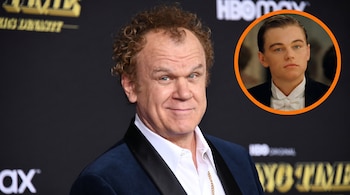 El actor John C. Reilly, con cabello rizado y una chaqueta de terciopelo azul, sonríe a la cámara. Un pequeño círculo naranja muestra a un joven Leonardo DiCaprio.
