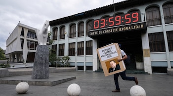 Fachada de la Corte de Constitucionalidad, reloj digital '03:59:59', estatua de caballo, hombre corriendo con cartel de 'EXPEDIENTE - AMPARO - WALTER MAZARIEGOS USAC' con foto.
