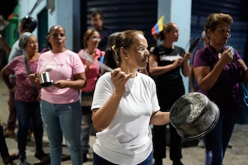 Varias personas golpean cacerolas durante una protesta contra los cortes de electricidad en San Mateo, Venezuela, el martes 18 de agosto de 2026. (AP Foto/Ariana Cubillos)