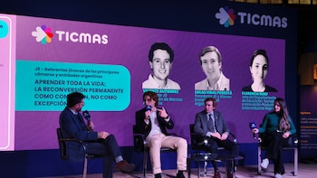 Cuatro panelistas, tres hombres y una mujer, sentados en un escenario con micrófonos, frente a una pantalla grande morada con el logo de TICMAS y retratos