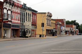 Vista diurna de una calle principal con una fila de edificios comerciales de ladrillo y fachadas coloridas a lo largo de East Cass Street en Rock Port