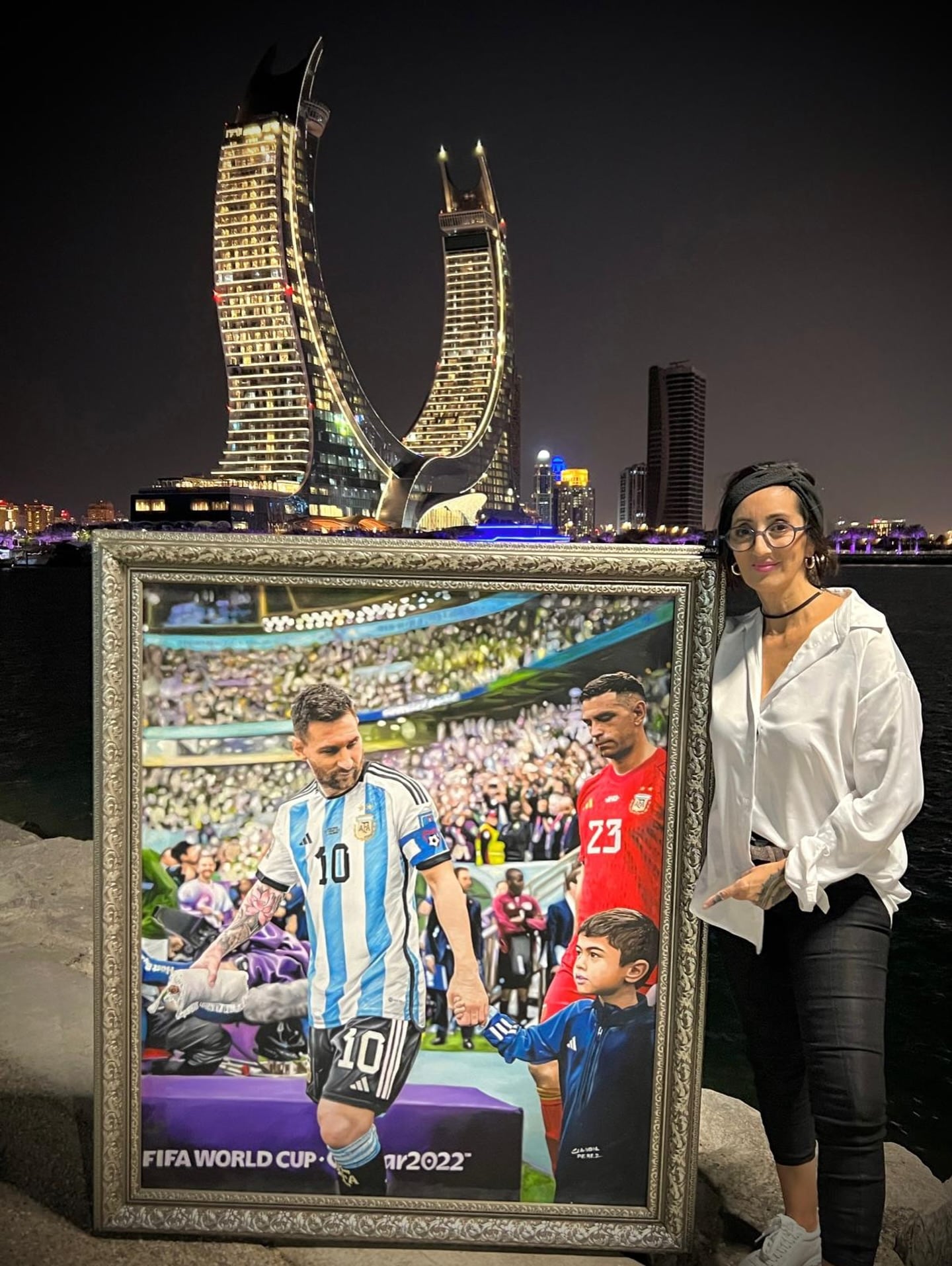 Claudia junto a un cuadro de Messi y Dibu Martínez (Instagram: @claudiaperezart)