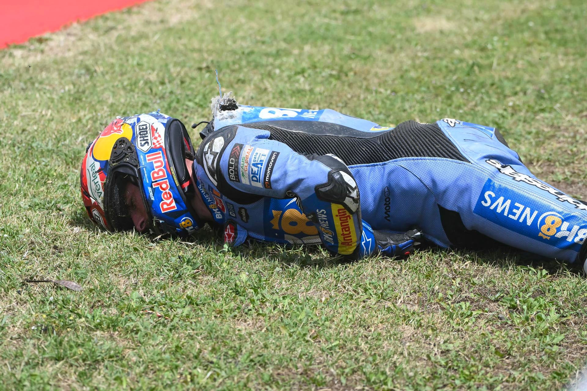 Alex Márquez yace en el césped tras su accidente en el GP de Cataluña dee MotoGP (AFP)