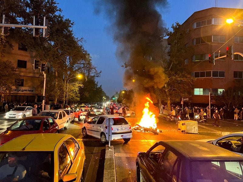 Una moto de la policía arde durante una protesta por el asesinato de Mahsa Amini, en Teherán, Irán, el 19 de septiembre, 2022 (REUTERS)