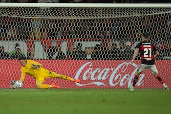 El arquero uruguayo Fernando Muslera, de Estudiantes de la Plata, ataja un penal ejecutado por Jorginho, de Flamengo, en la tanda para definir la semifinal de la Copa Libertadores en Río de Janeiro, el jueves 22 de octubre de 2026 (AP Foto/Silvia Izquierdo)