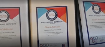 Tres diplomas enmarcados de récord mundial con el nombre de Edward Molineaux y detalles sobre carreras de media maratón y ultramaratón