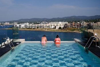 Dos turistas disfrutan de la piscina en la azotea de un hotel en Sant Antoni de Portmany, en la costa de Ibiza, España (Nacho Doce / Reuters)