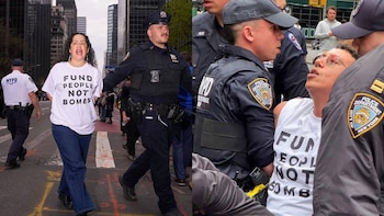 Manifestantes y agentes de policía en una calle urbana. Una mujer con una camiseta 'FUND PEOPLE NOT BOMBS' y un manifestante siendo sujetado por policías son visibles