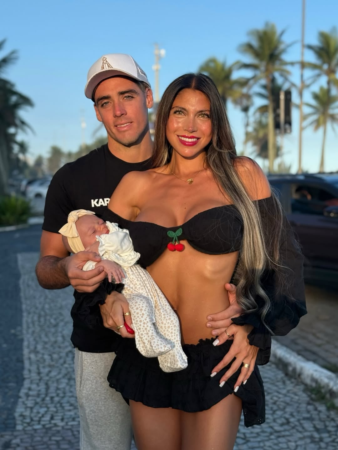 El futbolista Claudio Spinelli y Cielo López posan al aire libre junto a su bebé recién nacido.