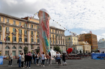 Un grupo de personas observa la nueva instalación del artista Gaetano Pesce de una "Pulcinella" estilizada llamada 'Tu si' 'na cosa grande' ('Tú eres una cosa grande' en dialecto napolitano)
