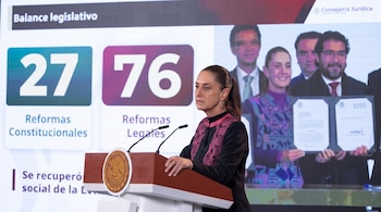 Claudia Sheinbaum habla desde un podio con el escudo de México frente a una pantalla sobre reformas constitucionales y legales.