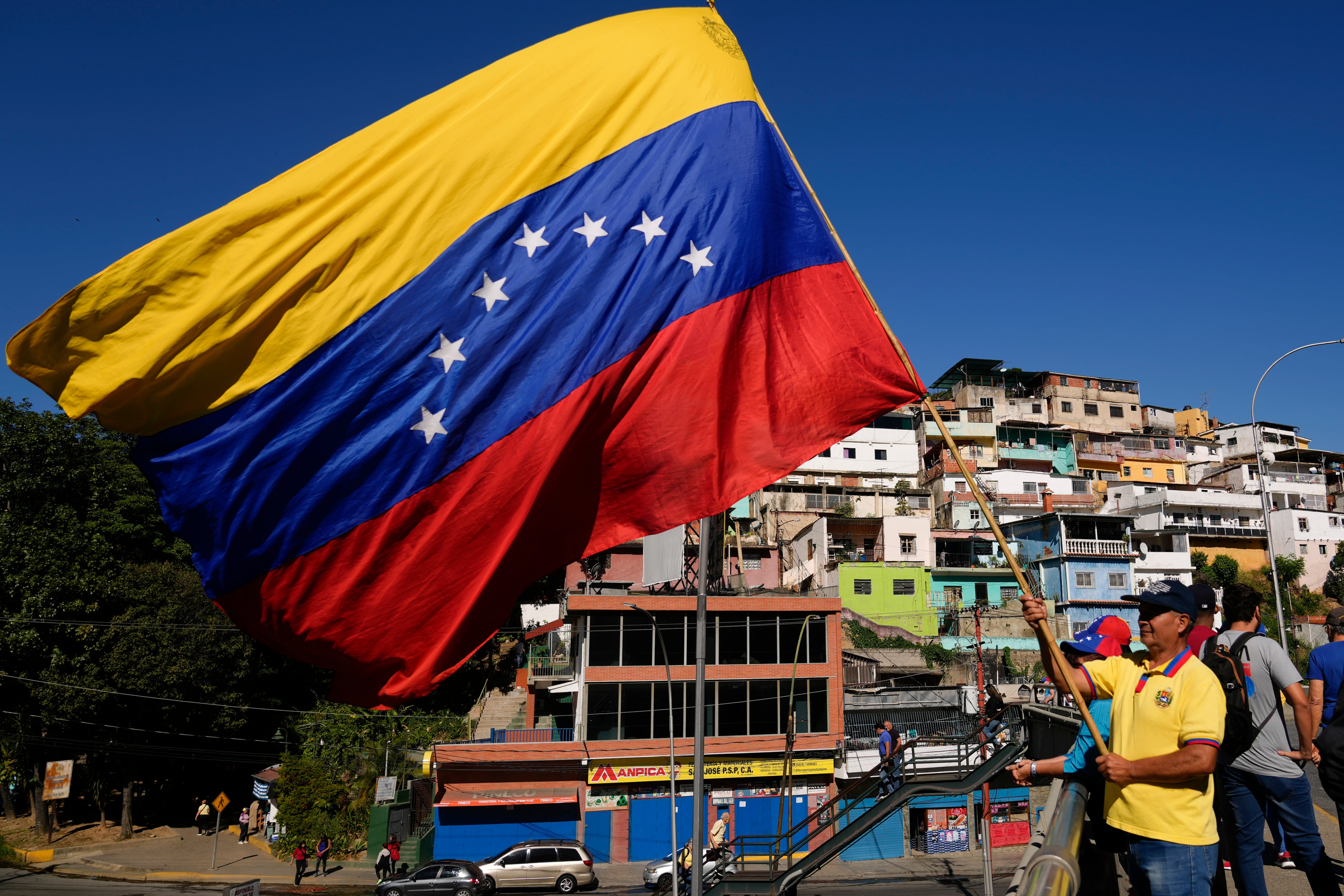 Un hombre con la bandera de Venezuela (AP Foto/Ariana Cubillos)
