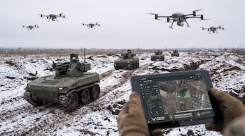 Campo cubierto de nieve con varios drones aéreos y vehículos terrestres robotizados. Una mano enguantada sostiene una tableta con un mapa de Lyptsi, Ucrania.