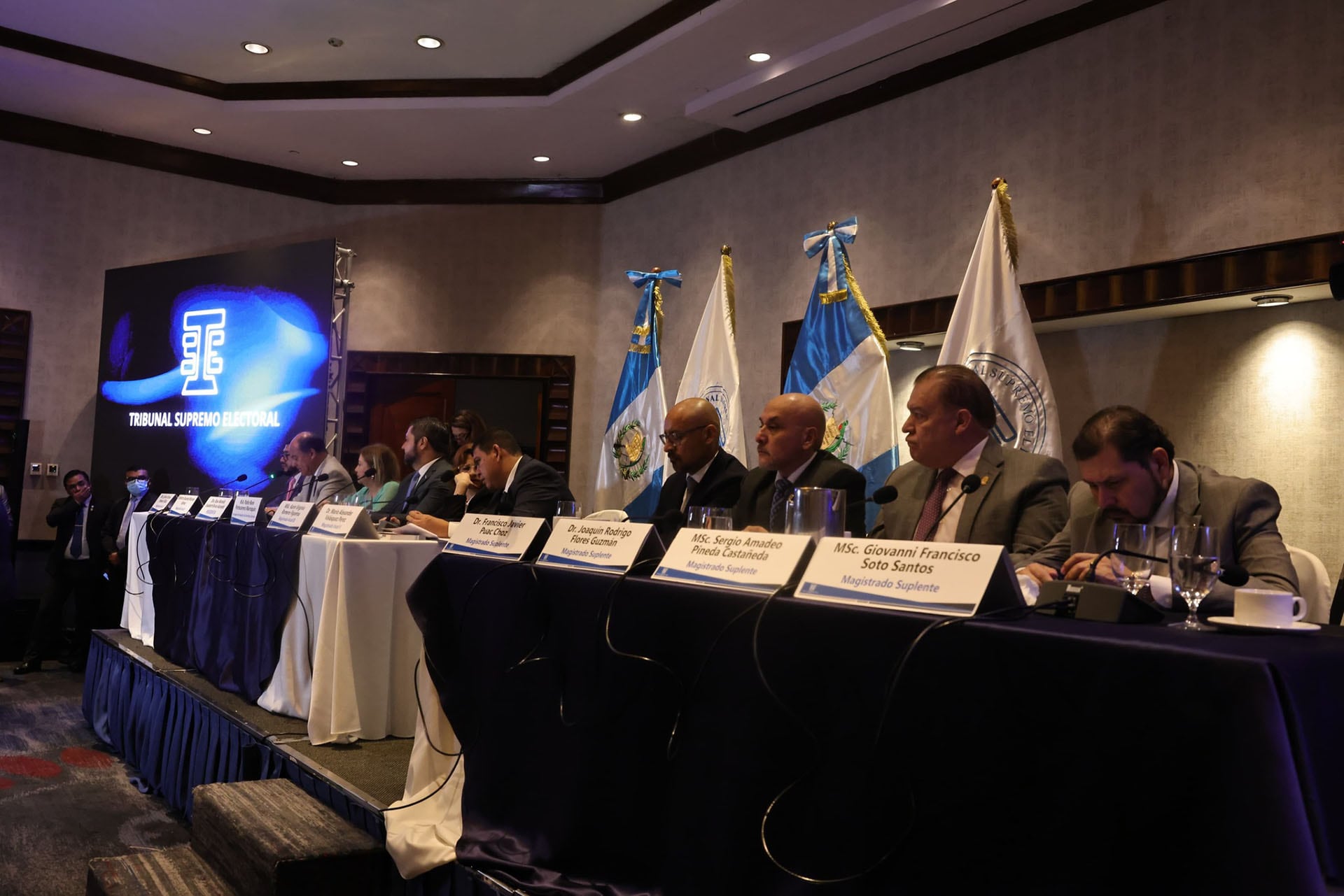 Miembros del Tribunal Supremo Electoral de Guatemala se reúnen con dirigentes de partidos políticos en un salón de conferencias, con banderas nacionales y el logo institucional visibles al fondo. (Diario de Centroamérica)