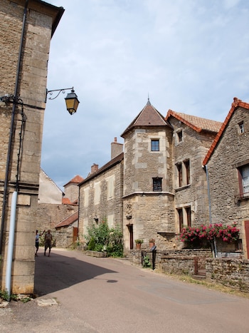 Una calle del pueblo francés en el que se aprecian edificios con muros de piedra con las esquinas de caliza y los tejados amplios pero chatos.