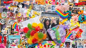 Mesa llena de objetos de Harry Styles como fotos, pines, stickers, llaveros, gomitas de colores en una bolsa y un billete mexicano modificado.